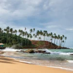 Tropical beach with palm trees and clear blue sea on the southern coast of Sri Lanka