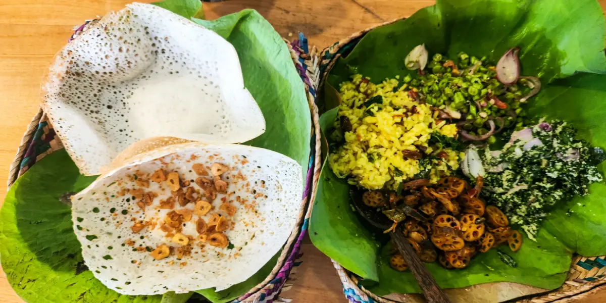 Traditional Sri Lanka hoppers served on banana leaf with rice and vegetable side dishes