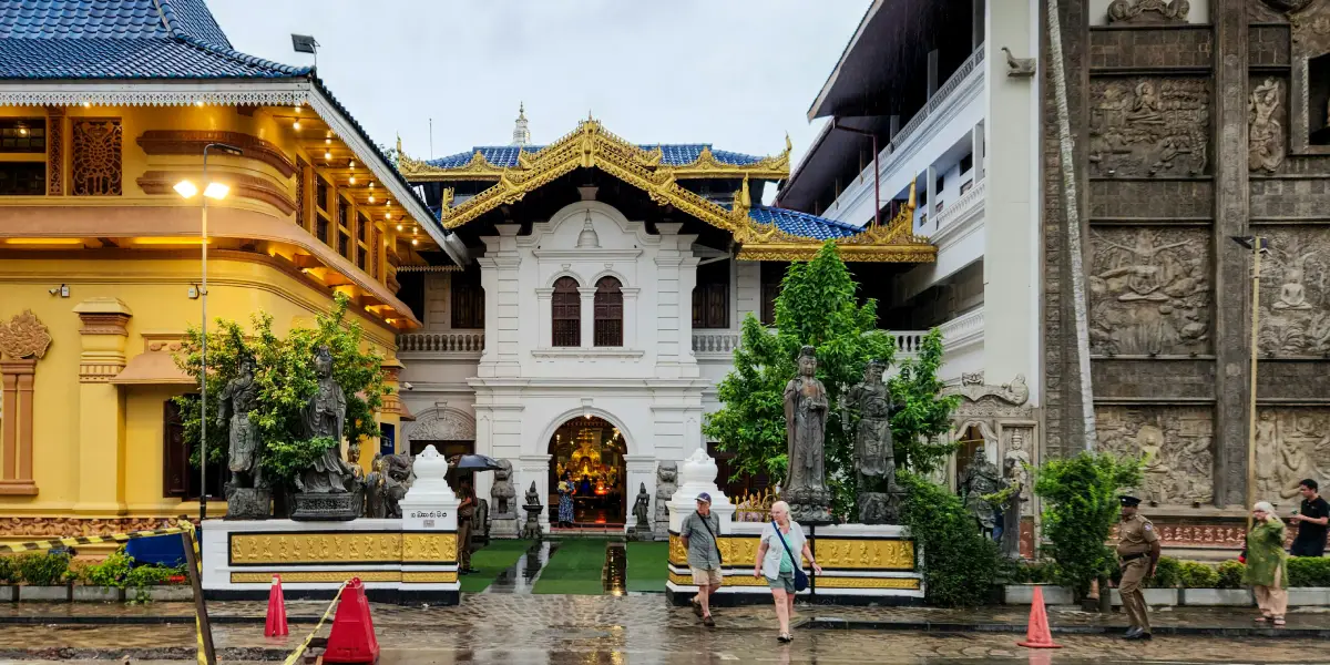 International visitors walking outside Gangaramaya Buddhist Temple complex in Colombo Sri Lanka